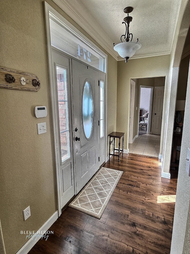 entrance foyer with wood finished floors, crown molding, and a textured wall