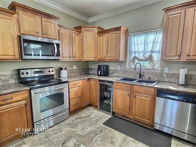 kitchen with a sink, wine cooler, appliances with stainless steel finishes, crown molding, and brown cabinets