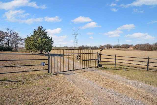 view of gate with a rural view and fence