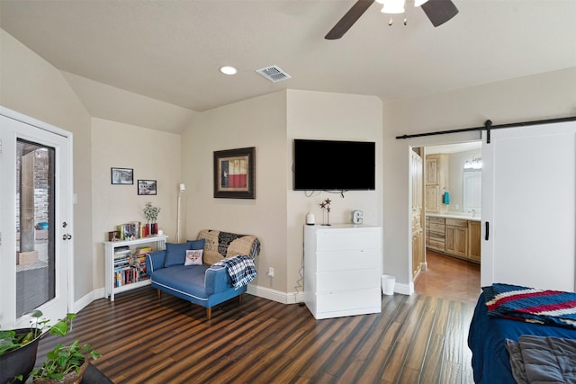 interior space featuring a barn door, a ceiling fan, visible vents, and baseboards