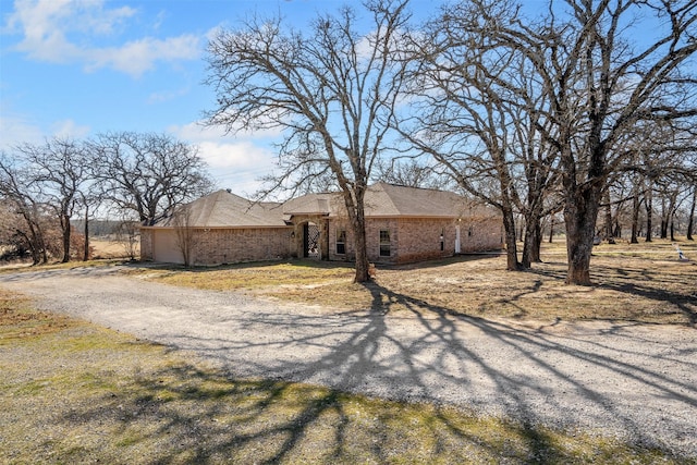 view of front facade featuring an attached garage, brick siding, and driveway