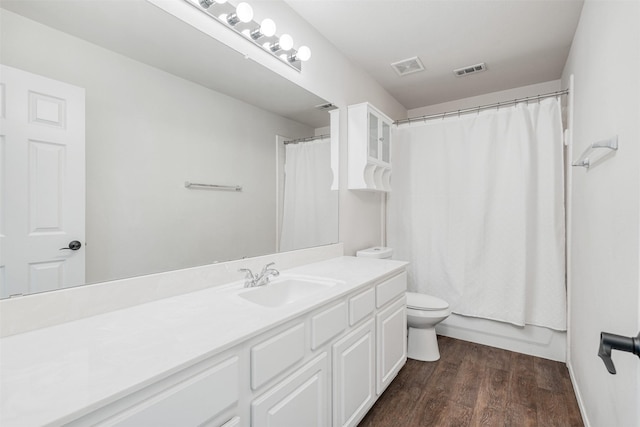 bathroom featuring visible vents, toilet, vanity, and wood finished floors