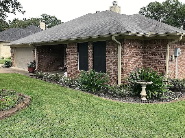 view of home's exterior featuring an attached garage, a lawn, brick siding, and a chimney