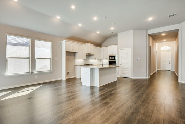 kitchen featuring visible vents, an island with sink, white cabinets, built in microwave, and dark wood-style flooring