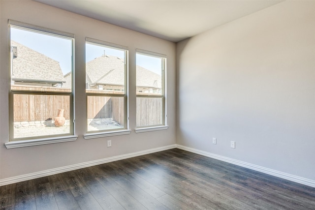 unfurnished room with dark wood-type flooring and baseboards