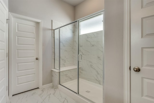 bathroom with baseboards, marble finish floor, and a shower stall