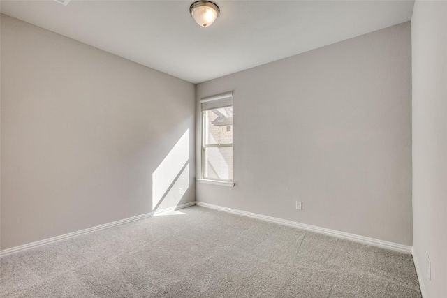 carpeted spare room featuring baseboards