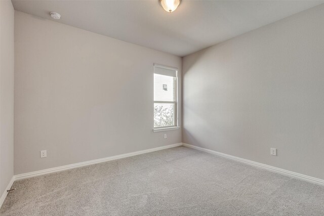 spare room with baseboards and carpet floors