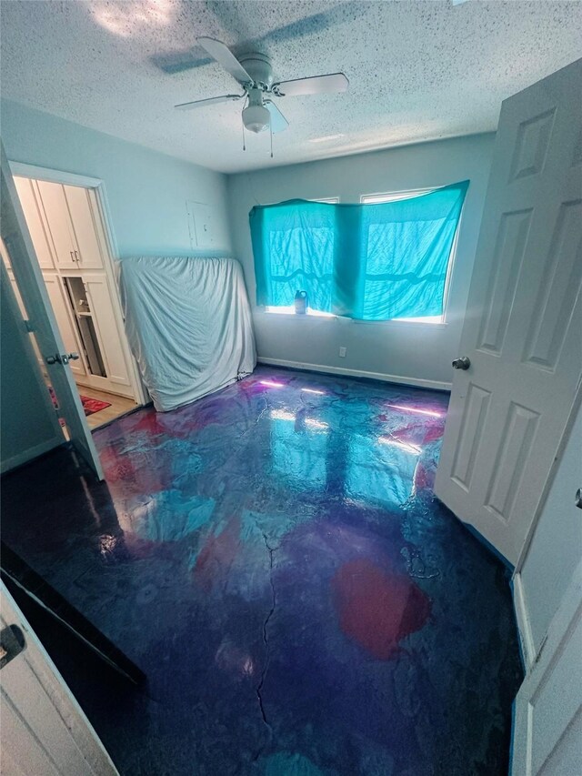 bedroom featuring a textured ceiling, concrete floors, and ceiling fan