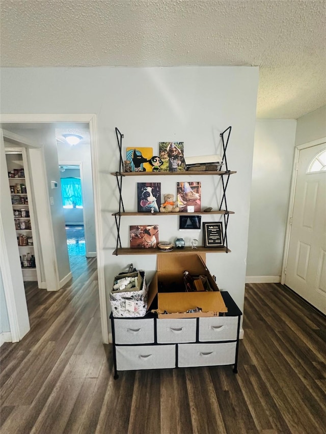 details with a textured ceiling, baseboards, and wood finished floors