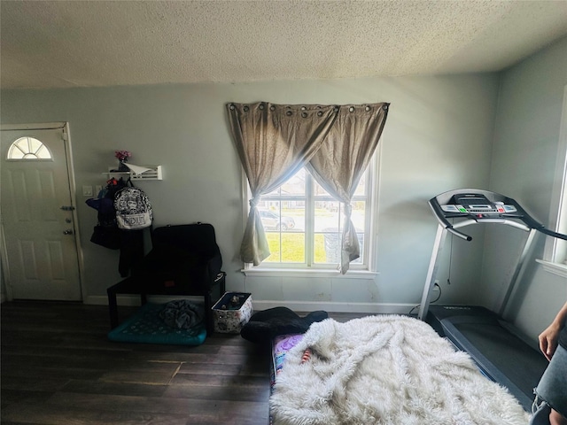 interior space featuring wood finished floors, baseboards, and a textured ceiling