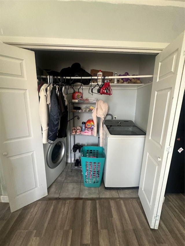 clothes washing area with washer / clothes dryer and wood finished floors