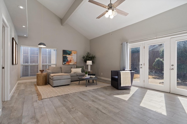 living area with beamed ceiling, high vaulted ceiling, a ceiling fan, light wood-style floors, and baseboards