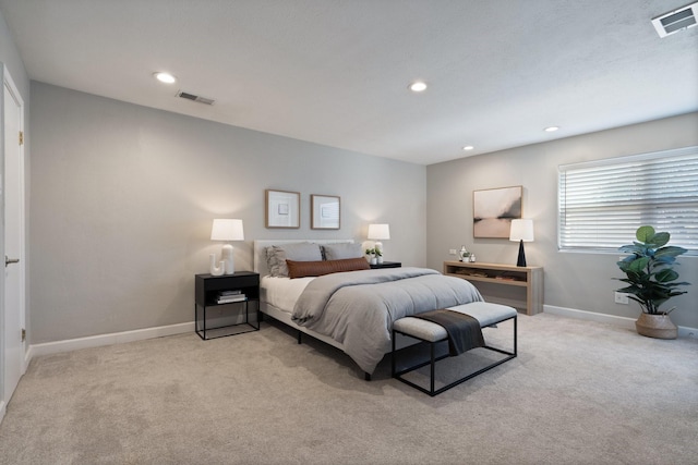 bedroom with light carpet, visible vents, and baseboards