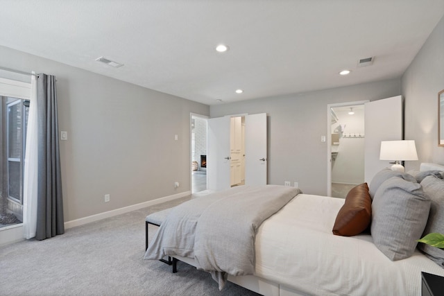 bedroom featuring visible vents, baseboards, a lit fireplace, carpet flooring, and recessed lighting