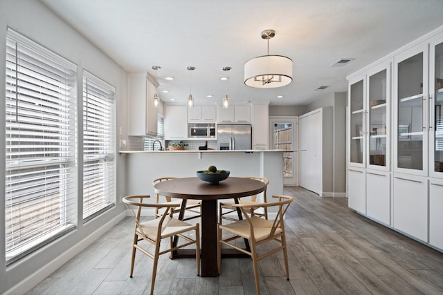 dining space featuring recessed lighting, baseboards, and light wood-type flooring