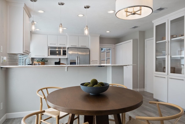 dining area featuring recessed lighting, visible vents, baseboards, and light wood finished floors