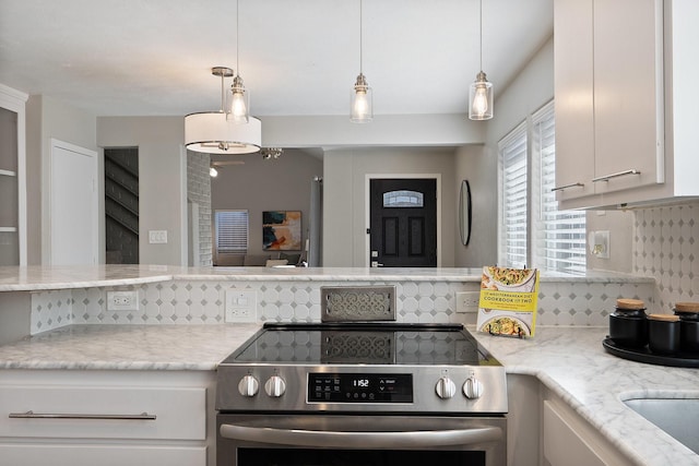 kitchen with white cabinetry, light stone counters, tasteful backsplash, and stainless steel range with electric cooktop