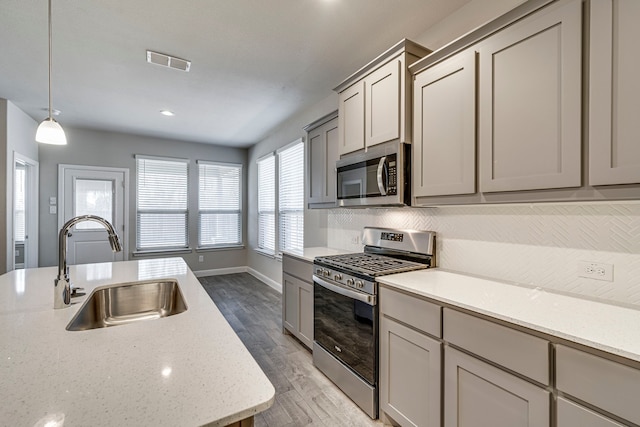 kitchen with visible vents, light wood-style flooring, appliances with stainless steel finishes, gray cabinets, and a sink