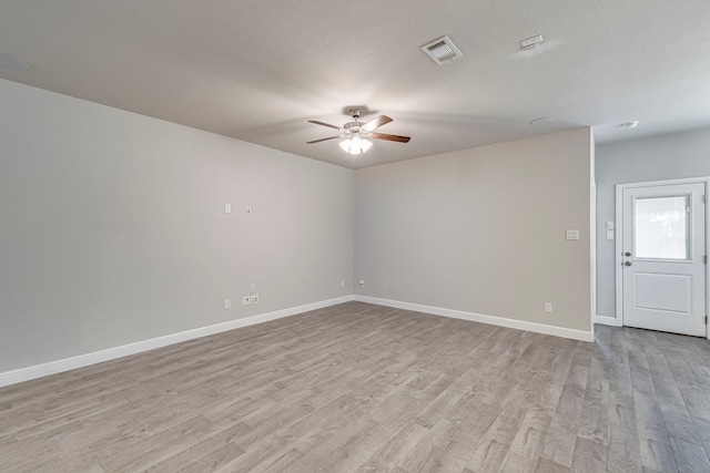 unfurnished room with a ceiling fan, baseboards, visible vents, and light wood finished floors