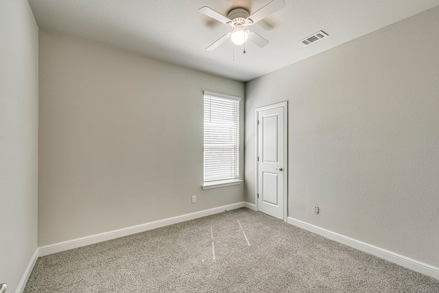 unfurnished room featuring light carpet, visible vents, baseboards, and a ceiling fan