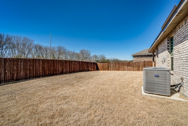 view of yard with central AC unit and a fenced backyard