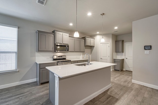 kitchen with a sink, appliances with stainless steel finishes, and gray cabinetry