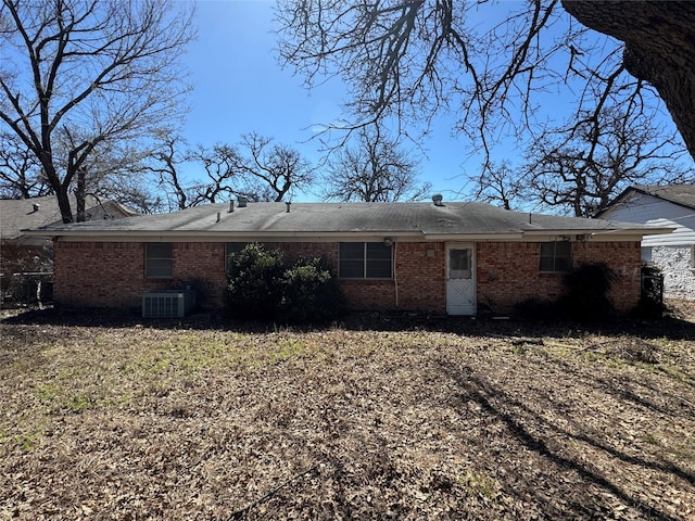 rear view of property with central air condition unit and brick siding