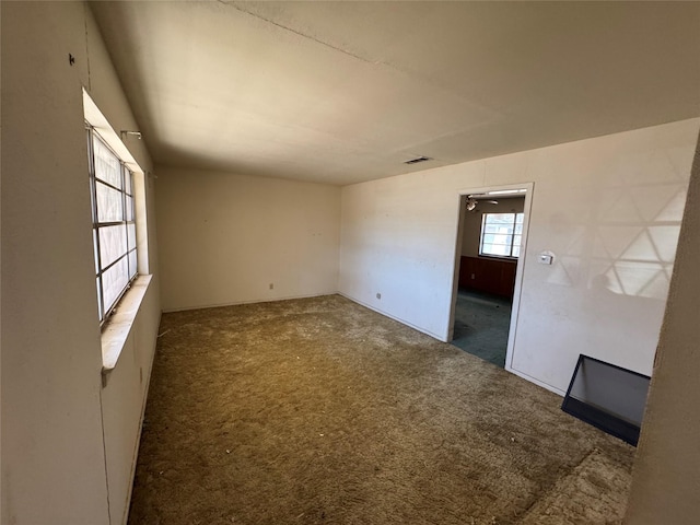 empty room with visible vents and carpet flooring