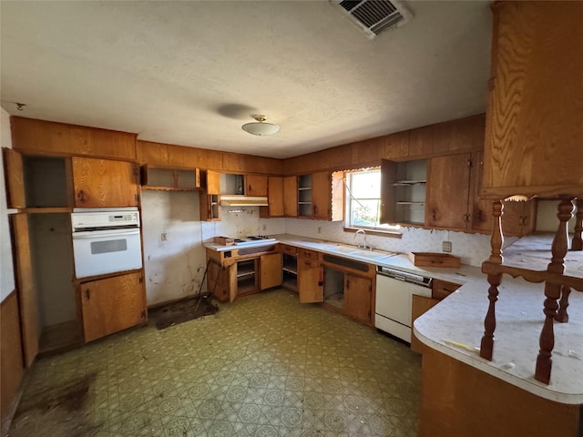 kitchen featuring open shelves, brown cabinetry, tile patterned floors, white appliances, and a sink