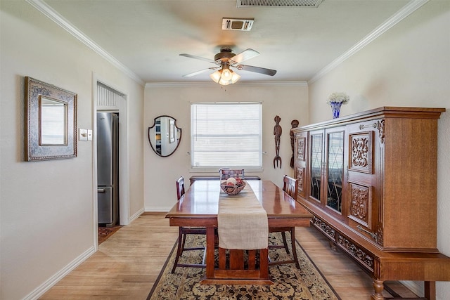 dining area featuring light wood-style flooring, baseboards, visible vents, and ornamental molding