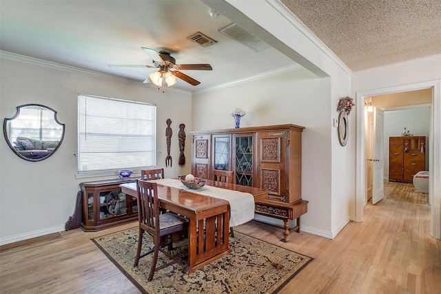 dining space featuring visible vents, baseboards, crown molding, and light wood-style floors