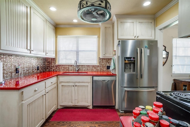 kitchen featuring a wealth of natural light, decorative backsplash, appliances with stainless steel finishes, and a sink