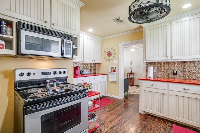 kitchen with visible vents, ornamental molding, backsplash, dark wood-style floors, and stainless steel appliances