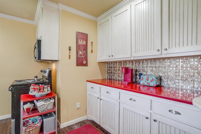 kitchen with tasteful backsplash, dark wood-type flooring, baseboards, gas range, and ornamental molding