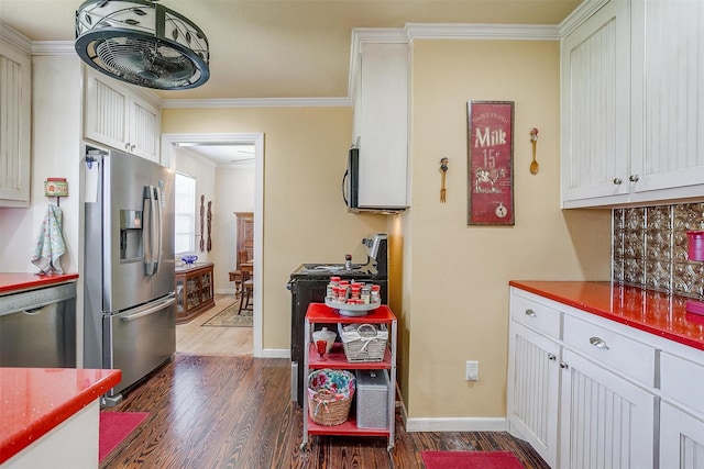 kitchen featuring baseboards, ornamental molding, dark wood-type flooring, white cabinets, and appliances with stainless steel finishes