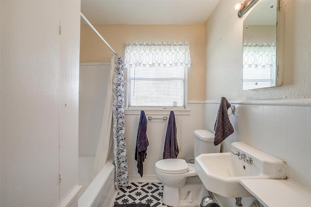 full bathroom with a sink, toilet, a healthy amount of sunlight, and shower / tub combo