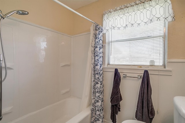 full bath with a wainscoted wall, toilet, tile walls, and shower / tub combo with curtain