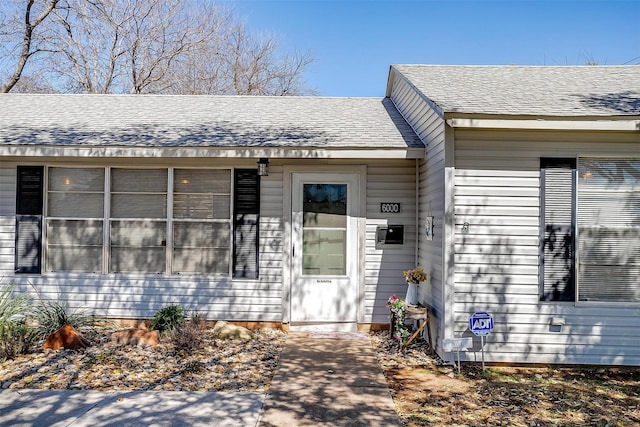 doorway to property featuring a shingled roof