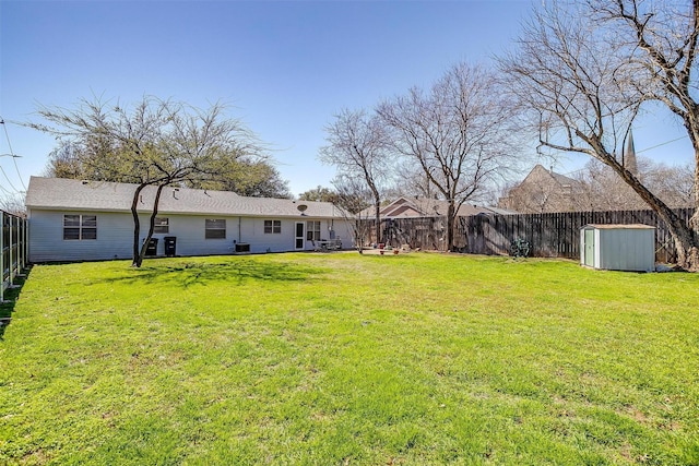 view of yard featuring an outdoor structure, a fenced backyard, and a storage shed