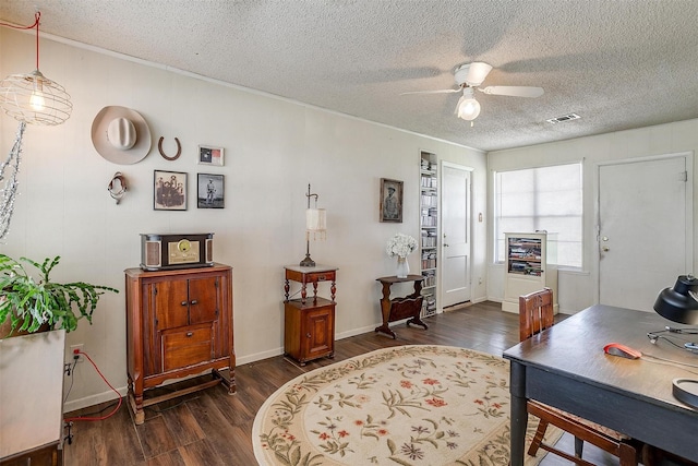 home office with visible vents, baseboards, ceiling fan, a textured ceiling, and dark wood-style flooring