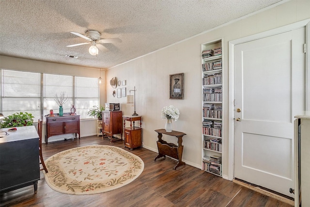 office with visible vents, a ceiling fan, a textured ceiling, wood finished floors, and crown molding