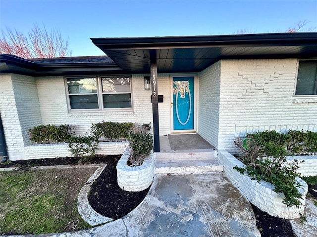 property entrance featuring brick siding