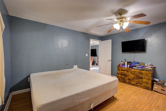 bedroom with light wood-type flooring, baseboards, and ceiling fan