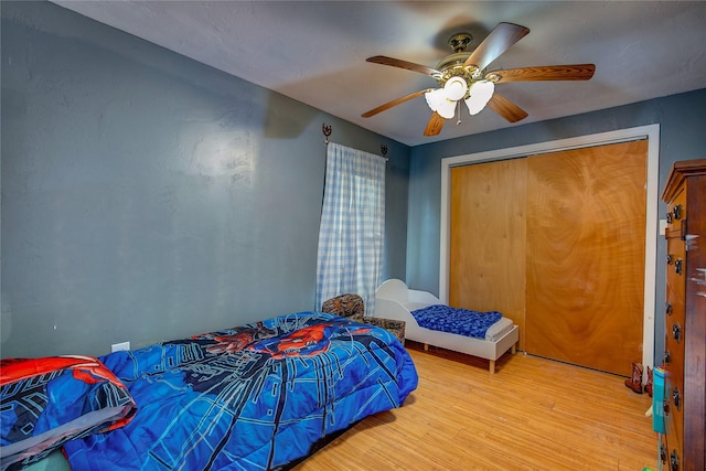 bedroom with a closet, a ceiling fan, and wood finished floors