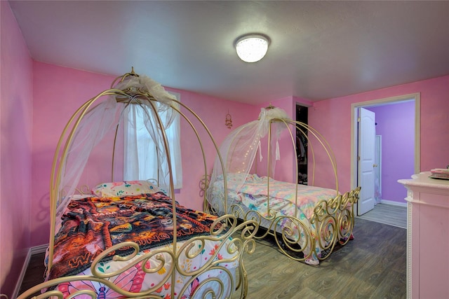 bedroom featuring baseboards and wood finished floors