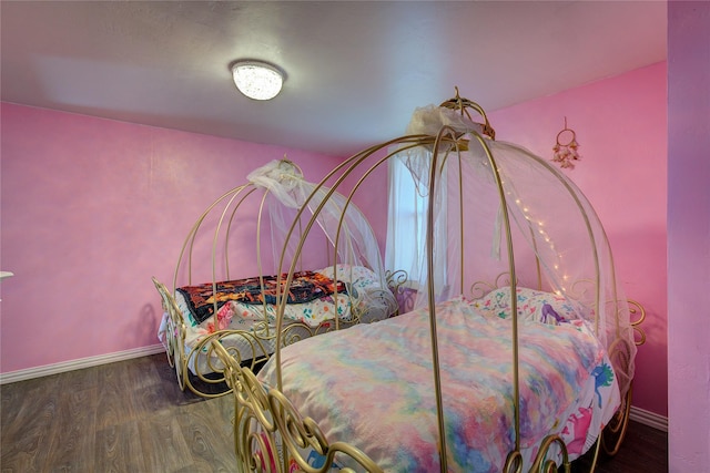 bedroom with baseboards and wood finished floors