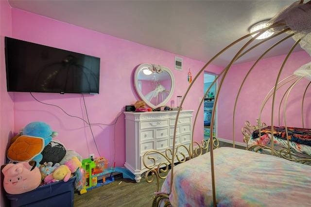 bedroom featuring visible vents and wood finished floors