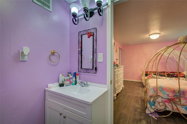 bathroom with visible vents, vanity, and wood finished floors