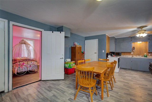 dining room with light wood finished floors and ceiling fan